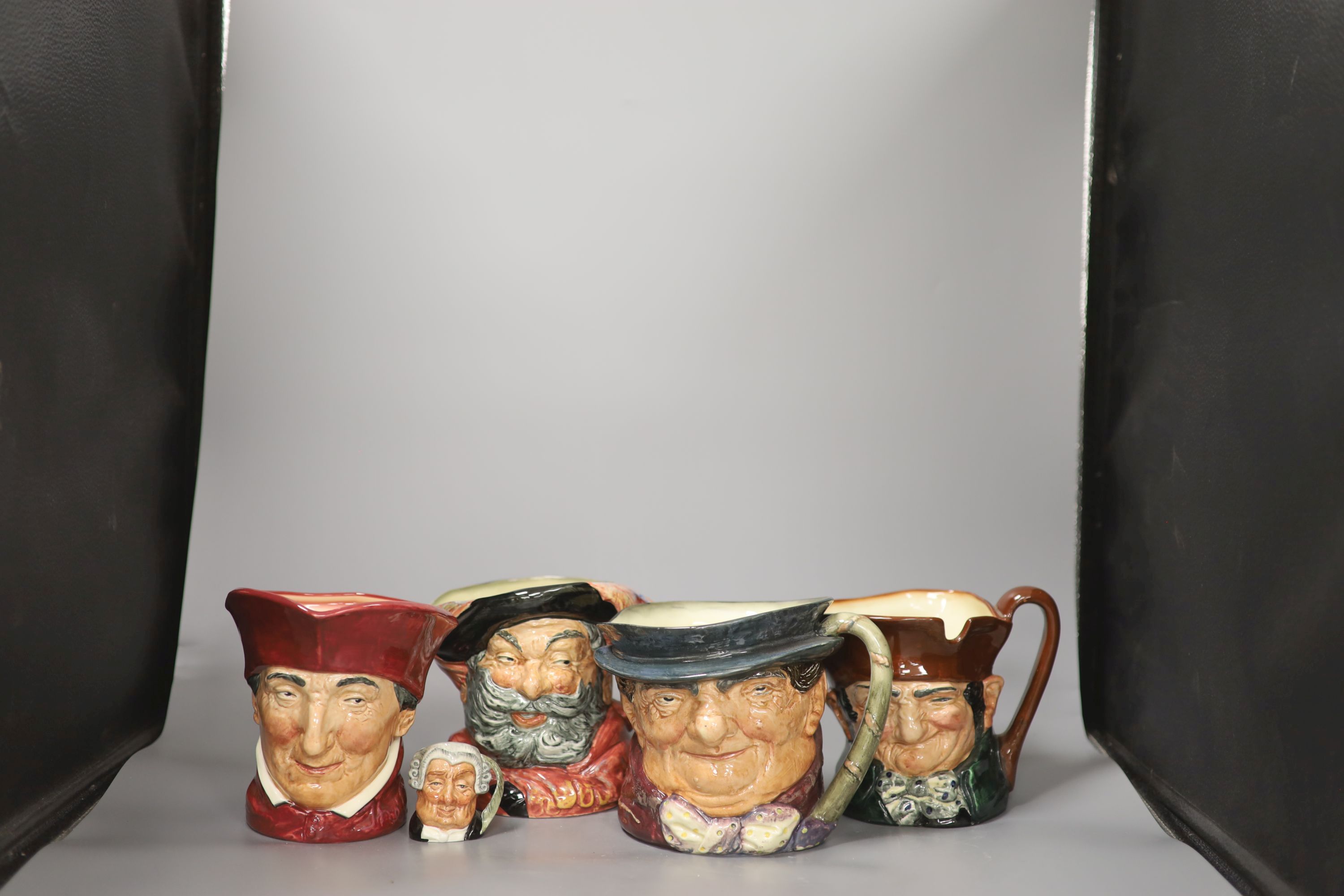 A group of four large Royal Doulton character jugs and one miniature character jug, including The Lawyer and Falstaff